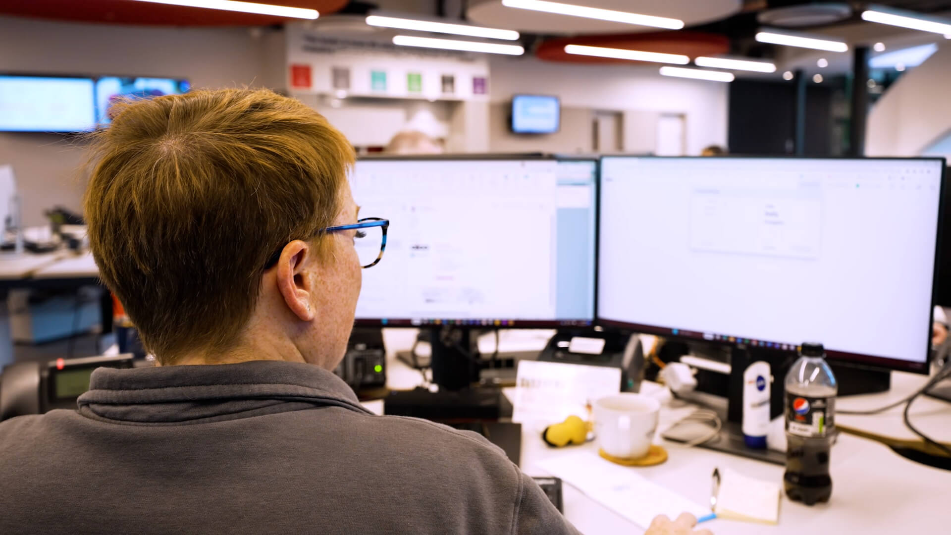 A man using a computer with two screens
